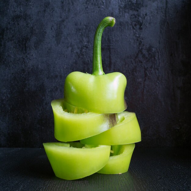 Groene paprika op zwarte achtergrond.