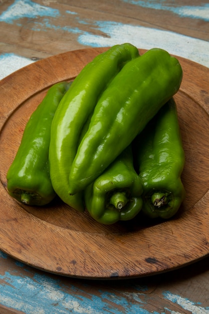 Groene paprika's op een houten bord