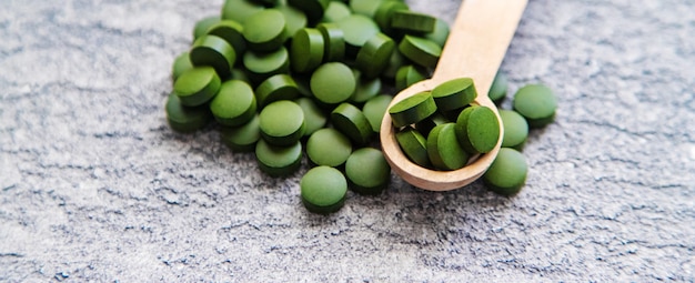 Groene pillen van chlorella en spirulina. Selectieve focusdrank