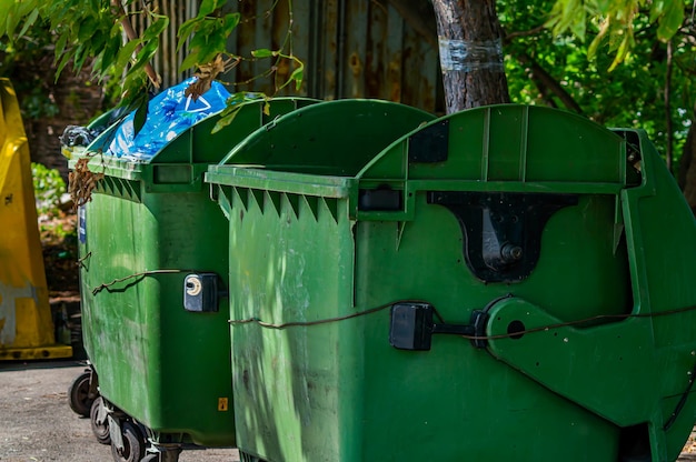 Foto groene plastic bakken voor afval afval op straat vuilnisbak een plaats voor het verzamelen van menselijke afval vervuiling van stadsstraten ecologie in de stad openbare plaats