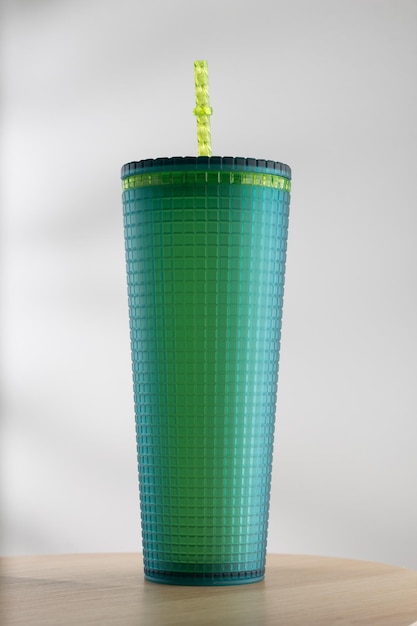 Groene plastic beker maat 22 ounces op een houten tafel