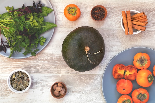 Groene Pompoen, Dadelpruimen en ingrediënten voor het smakelijke vegetarische koken op lichte houten oppervlakte