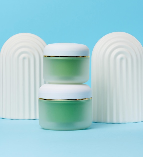 Groene pot voor cosmetica op een witte tafel Verpakking voor reclame en promotie van crème gel serum