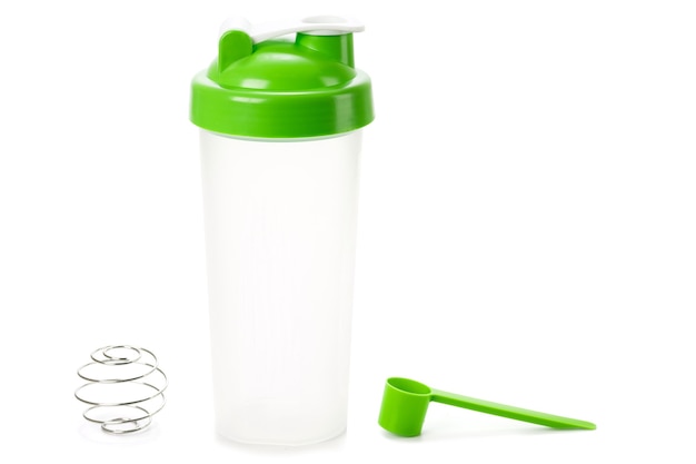 Groene proteïne shaker en lepel geïsoleerd op wit