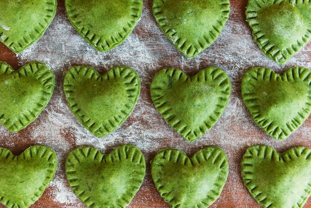 Groene Ravioli in de vorm van een hart op een houten ondergrond