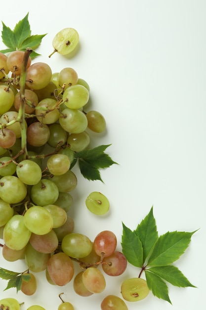 Groene rijpe druif met bladeren op witte achtergrond