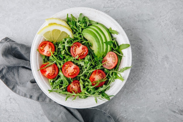 Groene salade met blaadjes rucola tomaten en avocado Gezonde zomerlunch