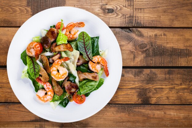 Groene salade met garnalen op achtergrond