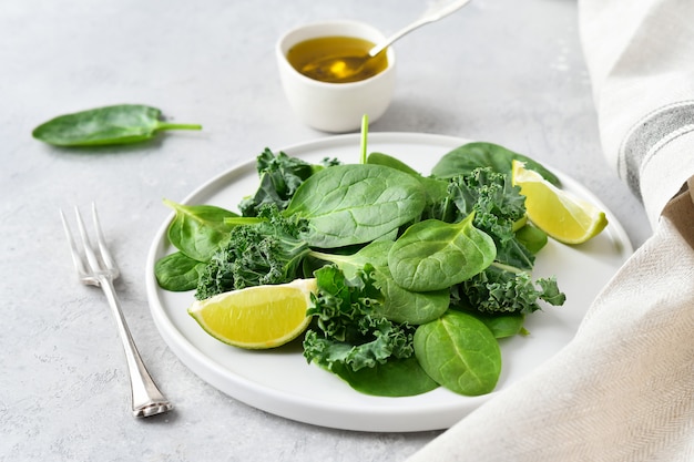 Groene salade van biologische spinazie en boerenkoolbladeren met citroensap en olijfolie.