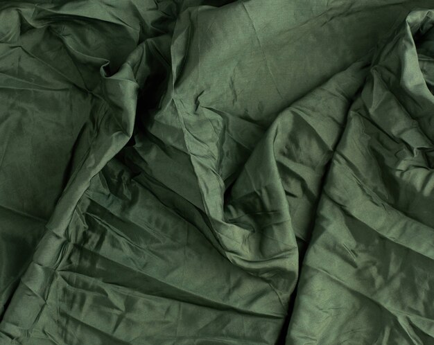 Groene satijnen textielstof, stuk stof voor het naaien van gordijnen en zo