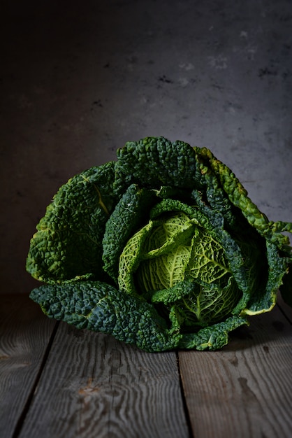 Foto groene savooiekool op een donkere close-up als achtergrond. gezonde groente.