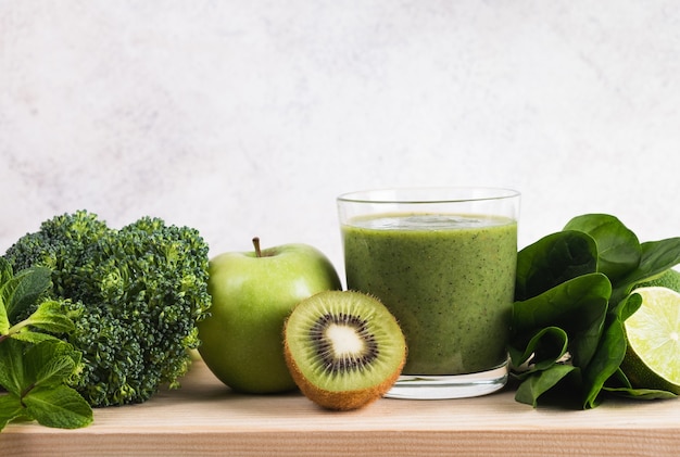 Groene smoothie en ingrediënten op keukentafel