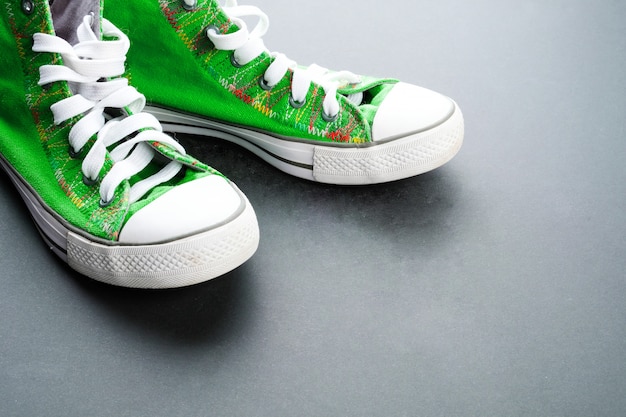 Foto groene sneakers op een donkere vloer