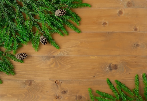 Groene sparren takken op een lichte houten achtergrond. Nep kunstvuren tak op een houten tafel gemaakt van planken.