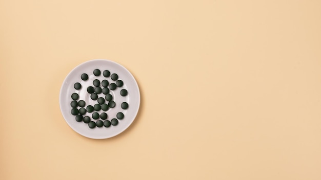 Groene Spirulina-pillen op het bord Bovenaanzicht Super Food Concept Spirulina-voedingssupplement