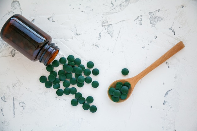 Groene spirulina-pillen vielen uit de fles