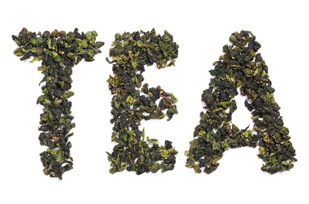 Groene thee bladeren tieguanyin oolong gerangschikt als woord op witte achtergrond, bovenaanzicht