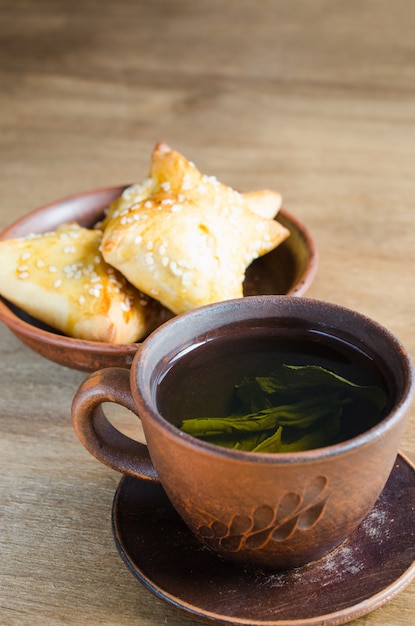 Groene thee en pastei op rustieke houten lijst