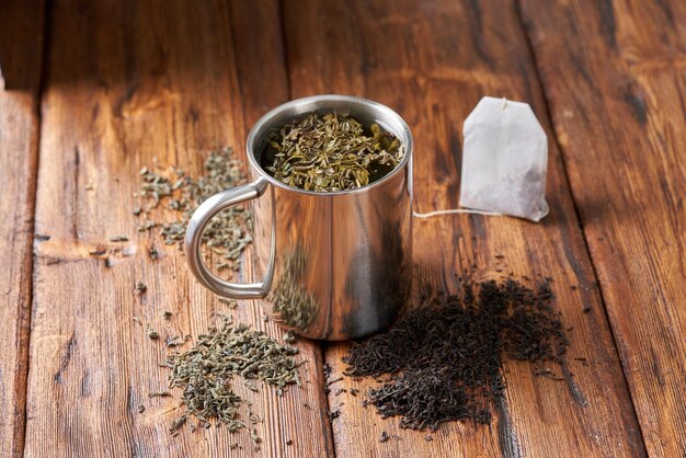 Groene thee in een roestvrij stalen beker op een oude houten tafel