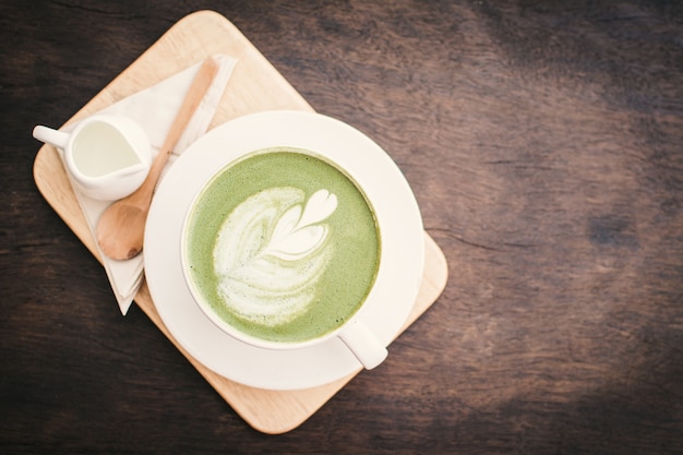 Groene theekop in de tijd van de koffiewinkel aan het ontspannen