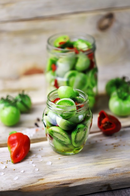 Groene tomaten in potten op een houten oppervlak. Landelijke stijl.