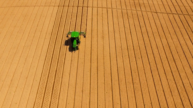 Groene tractor ploegen beluchten voor nieuwe aanplant boerderij landbouw