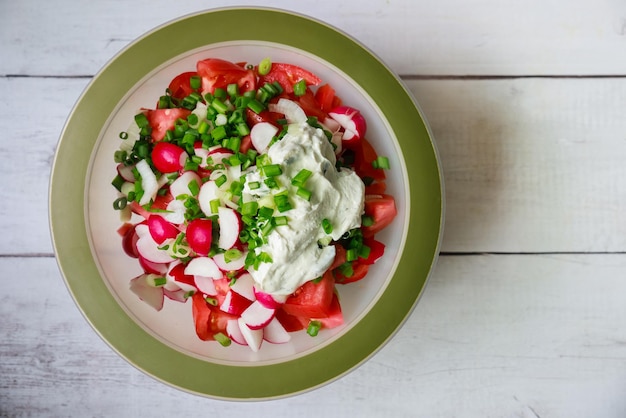 Groene ui, radijs en tomaten in een frisse groentesalade