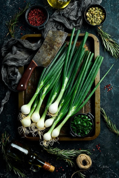 Groene uienkoppen op de keukentafel Bovenaanzicht Op een zwarte achtergrond Rustieke stijl