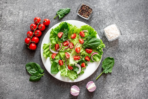 Groene veganistische salade van groenten en groene bladeren mix op stenen achtergrondGezond eten