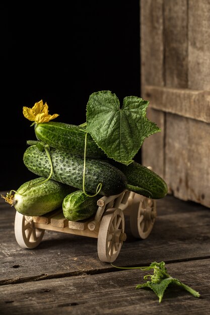 Groene verse komkommers op een houten kar.