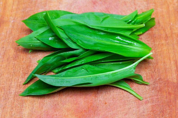 Groene verse ramson bladeren op een snijplank close-up