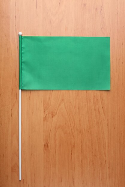 Groene vlag voor branding op houten tafel