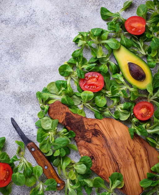 Groene voedselachtergrond met maïssla, tomaat en avocado