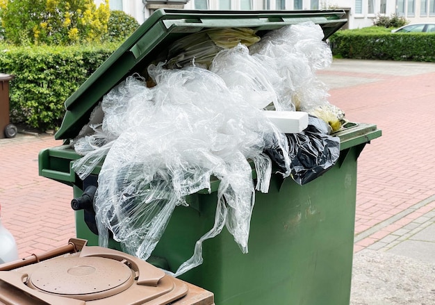 Foto groene vuilnisbak vol met plastic verpakkingsafval