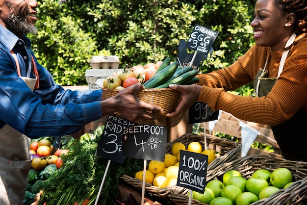 Foto groenteboer die organisch vers landbouwproduct voorbereiden bij landbouwersmarkt