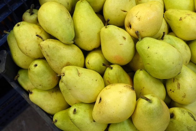 Groenteboer rijp peerpeerfruit klaar voor verkooplichtgele peren in het gangpad van de supermarktgroenteboer