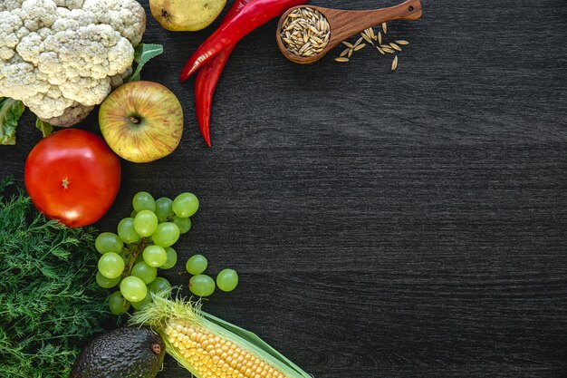 Groenten en fruit op een donkere houten ondergrond plat lag