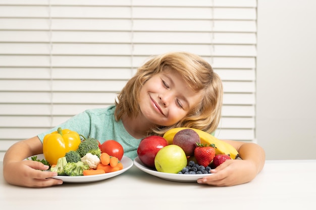 Groenten en fruit schoolkind dat ontbijt eet voordat school portret van kind thuis aan het bureau zit