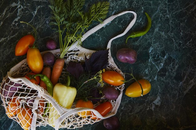 Groenten kleurrijke tomaten paarse aardappelen paprika wortelen basilicum dille in eco boodschappentas