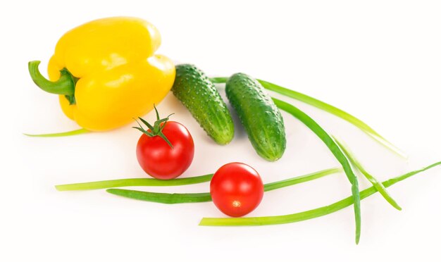 Groenten op de witte achtergrond broccoli tomaten komkommers en groene uien samenstelling van vege...