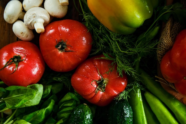 Groenten op een houten tafel Seizoensgroenten Tomaten paprika komkommers champignons op tafel