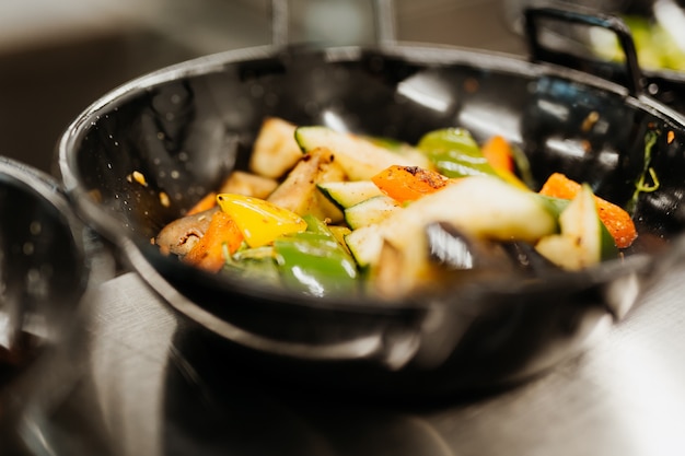 Foto groenten worden gebakken in een pan in olijfolie