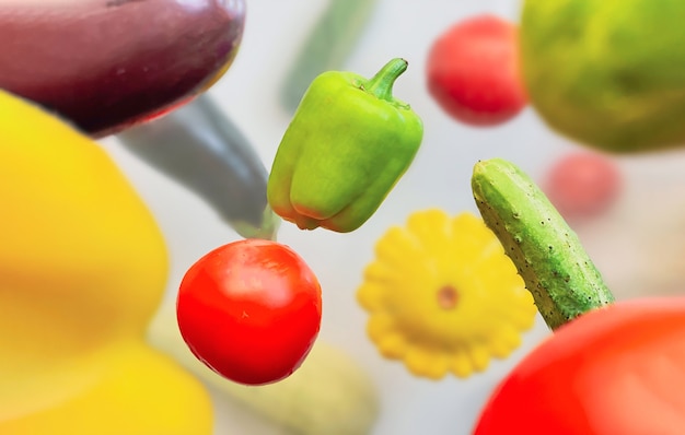 Foto groenten zweven in de lucht peper, komkommer, courgette, aubergine en tomaat op een witte achtergrond. gezond voedselconcept.