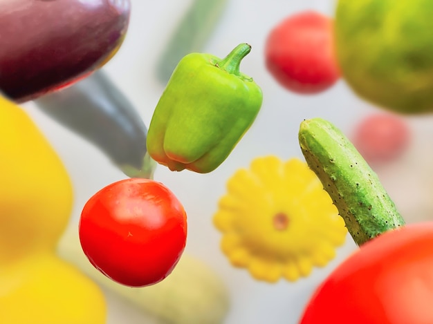 Groenten zweven in de lucht peper, komkommer, courgette, aubergine en tomaat op een witte achtergrond. Gezond voedselconcept