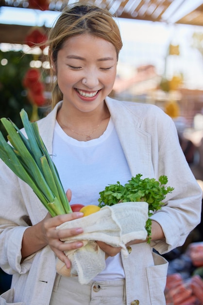 Groentenmarkt en tevreden klant of vrouw met voeding, gezond eten en boodschappen doen, korting en promotie Aziatische persoon met veganistische, milieuvriendelijke en duurzame boodschappen in de winkel