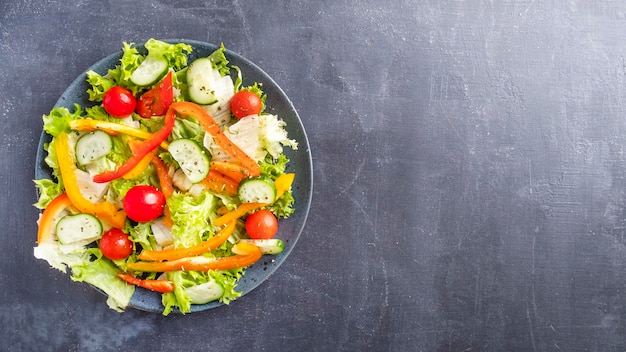 Groentensalade met paprika, tomaat en komkommer op een bord Bovenaanzicht tekstruimte