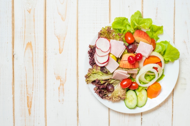 Groentensalade op schotel op witte houten lijst