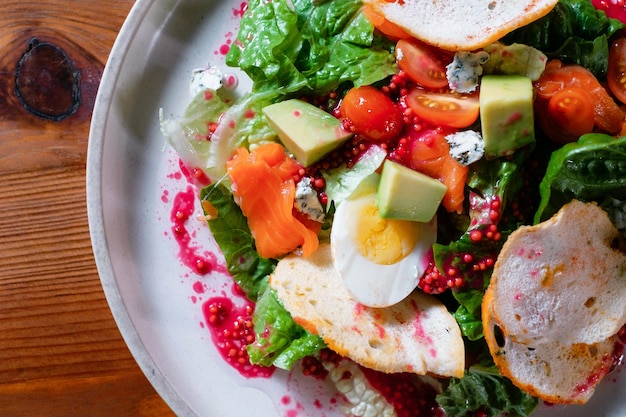 Groentesalade met eitomaatgranaatappel en avocado Een gezond gerecht op een witte plaat in een restaurantclose-up