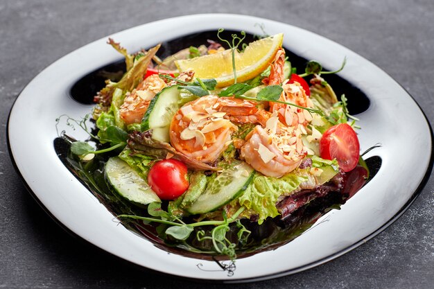 Groentesalade met garnalen, op een zwarte achtergrond