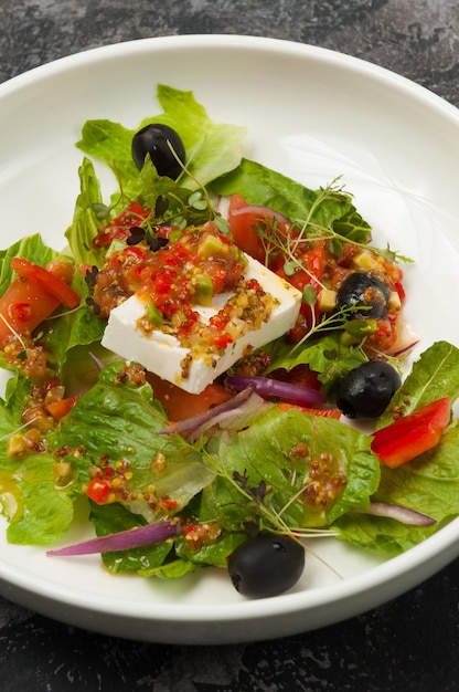 Groentesalade met ingelegde kaas op een witte plaat in een restaurant